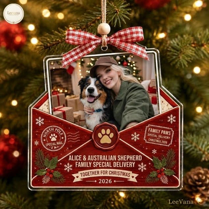 A custom envelope-shaped Christmas ornament featuring a photo of a person and an Australian Shepherd. The red wooden design includes a red and white gingham bow, a wax seal with a paw print, and text reading North Pole Special Mail.