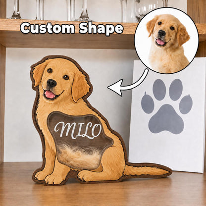 A custom-shaped wooden display in the silhouette of a golden retriever dog. The piece features a clear window section containing light-colored fur, with the name Milo printed in white script. Text above reads Custom Shape.