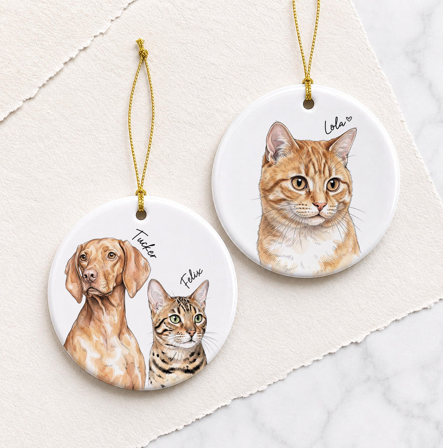 Two round white ceramic ornaments with gold hanging strings. One ornament features a brown dog labeled Tucker and a spotted cat labeled Felix. The second ornament features an orange tabby cat labeled Lola with a small heart icon.