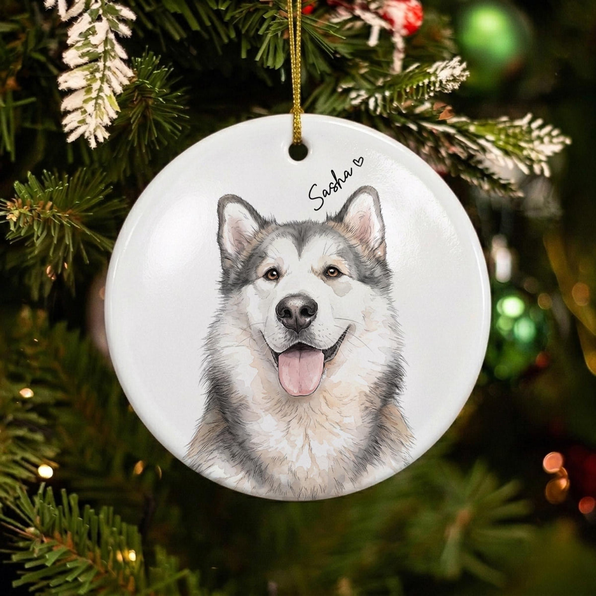 A round white ceramic ornament featuring a detailed illustration of a grey and white Alaskan Malamute dog with its tongue out. The name Sasha is printed in black cursive script above the dog's head, accompanied by a small heart icon.