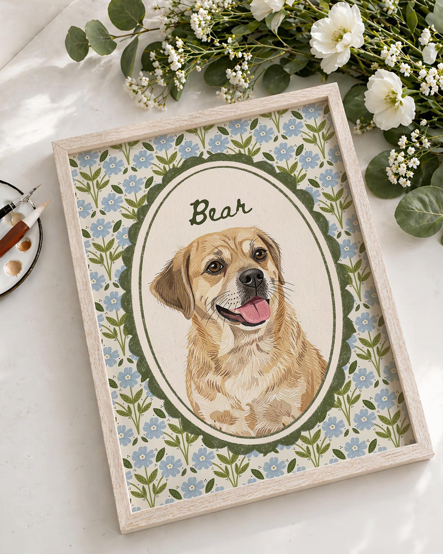 A framed portrait of a golden-colored dog with its tongue out, centered within a dark green scalloped oval frame. The background features a light blue floral pattern on a cream base, with the name Bear written in dark green script.