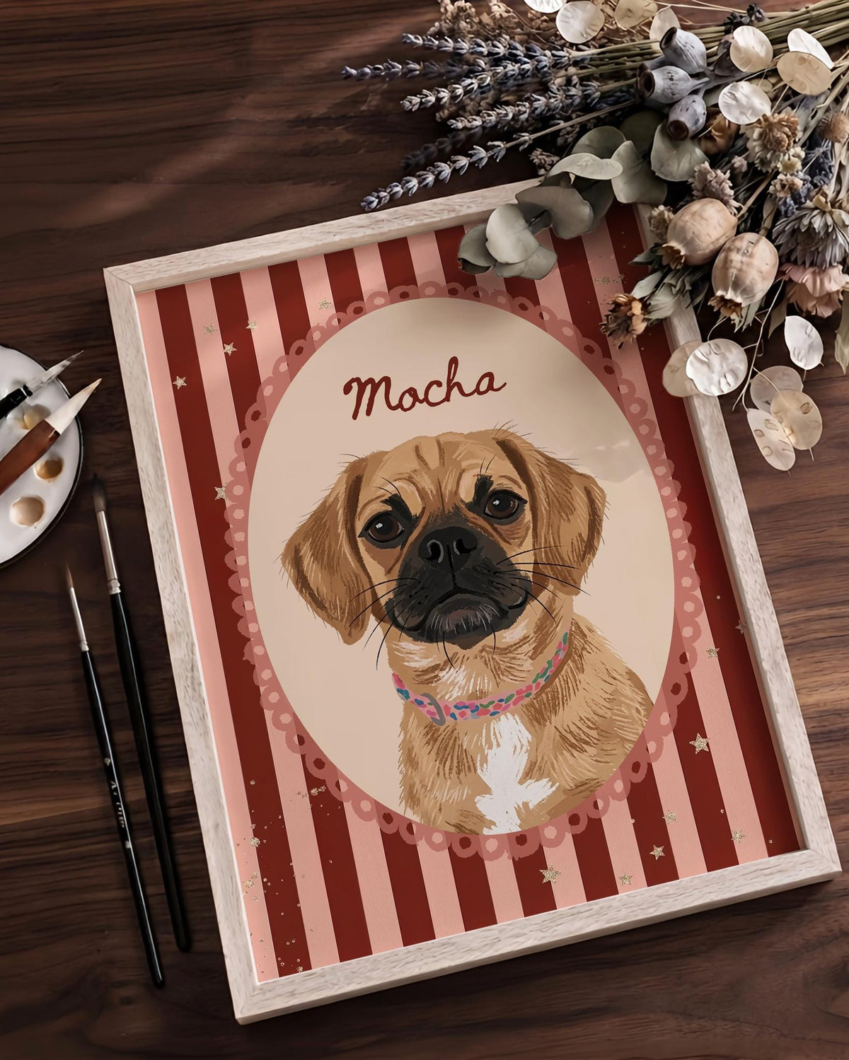 A framed portrait illustration of a tan dog with a black muzzle and a white chest patch, wearing a colorful patterned collar. The dog is centered in an oval frame against a background of vertical dark red and light pink stripes with stars.