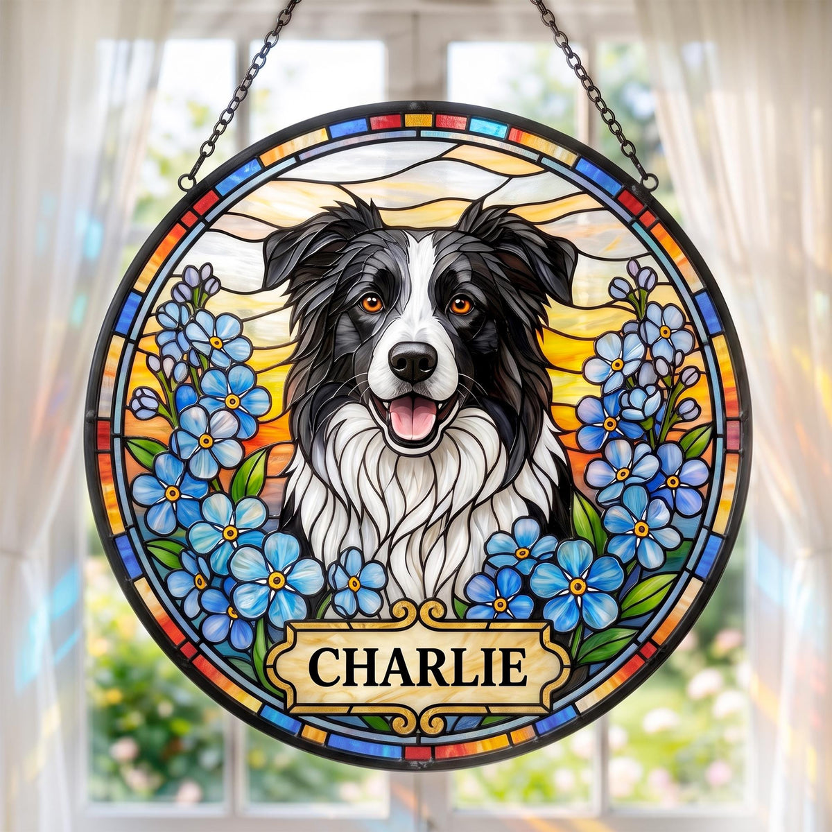 A circular stained glass suncatcher featuring a black and white Border Collie portrait surrounded by blue forget-me-not flowers. The piece includes a rectangular plaque at the bottom with the name CHARLIE in black capital letters.