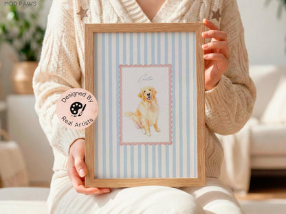 A framed print featuring a watercolor illustration of a golden retriever dog. The artwork is set against a light blue and white striped background, framed in natural wood. The print is labeled "Carter" and includes a "Designed by Real Artists" sticker.