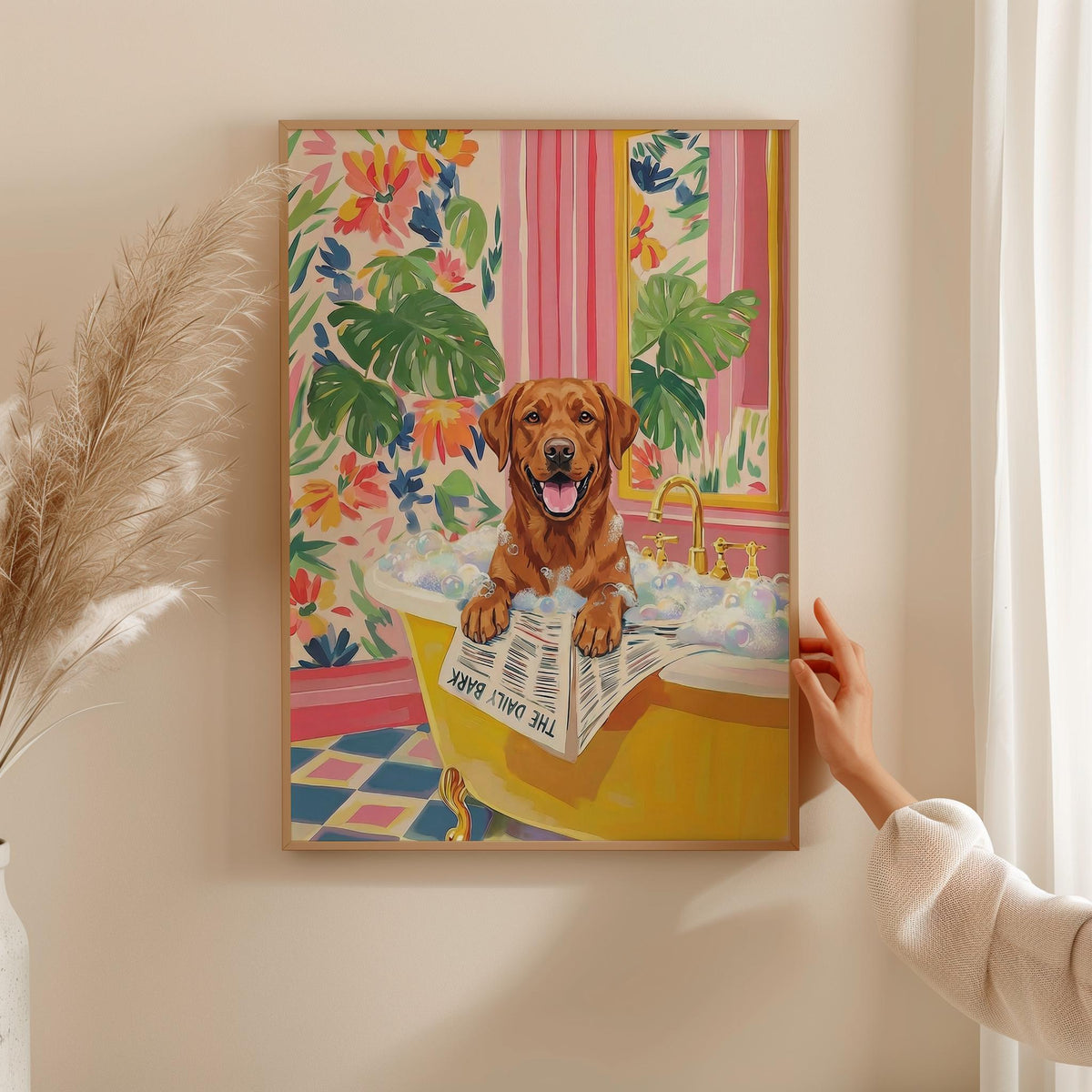 A framed print of a golden Labrador Retriever in a yellow bathtub filled with bubbles. The dog is holding a newspaper that reads "THE DAILY BARK". The background features floral wallpaper and pink striped curtains.