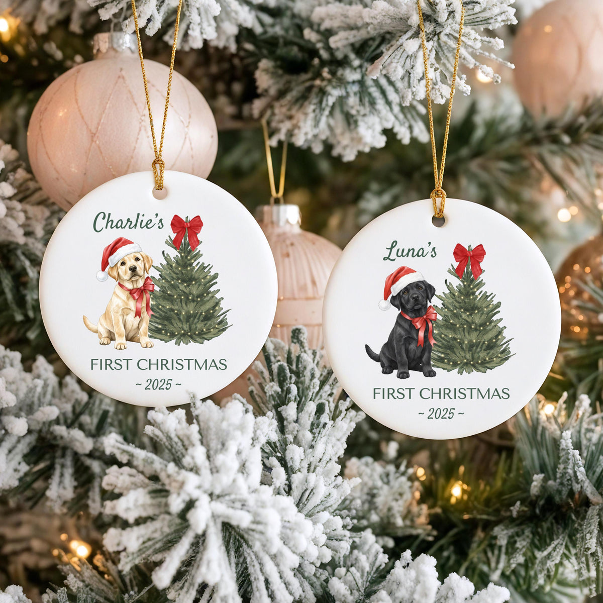 Two white ceramic Christmas ornaments with gold string hangers. One features a yellow lab puppy wearing a Santa hat and bow, with text "Charlie's FIRST CHRISTMAS - 2025". The other shows a black lab puppy with similar design and text "Luna's FIRST CHRISTMAS - 2025".