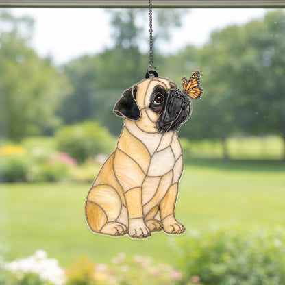 A stained glass suncatcher featuring a tan pug with a black muzzle and ears, sitting in profile. A small orange and black monarch butterfly is perched on the pug's nose. The piece is constructed with dark metal solder lines.