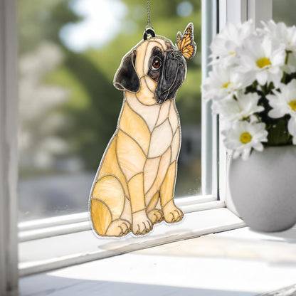 A stained glass suncatcher shaped like a fawn-colored pug with a black muzzle and ears, sitting upright. A small orange and black monarch butterfly is perched on the pug's nose. The piece is constructed with visible metal solder lines.