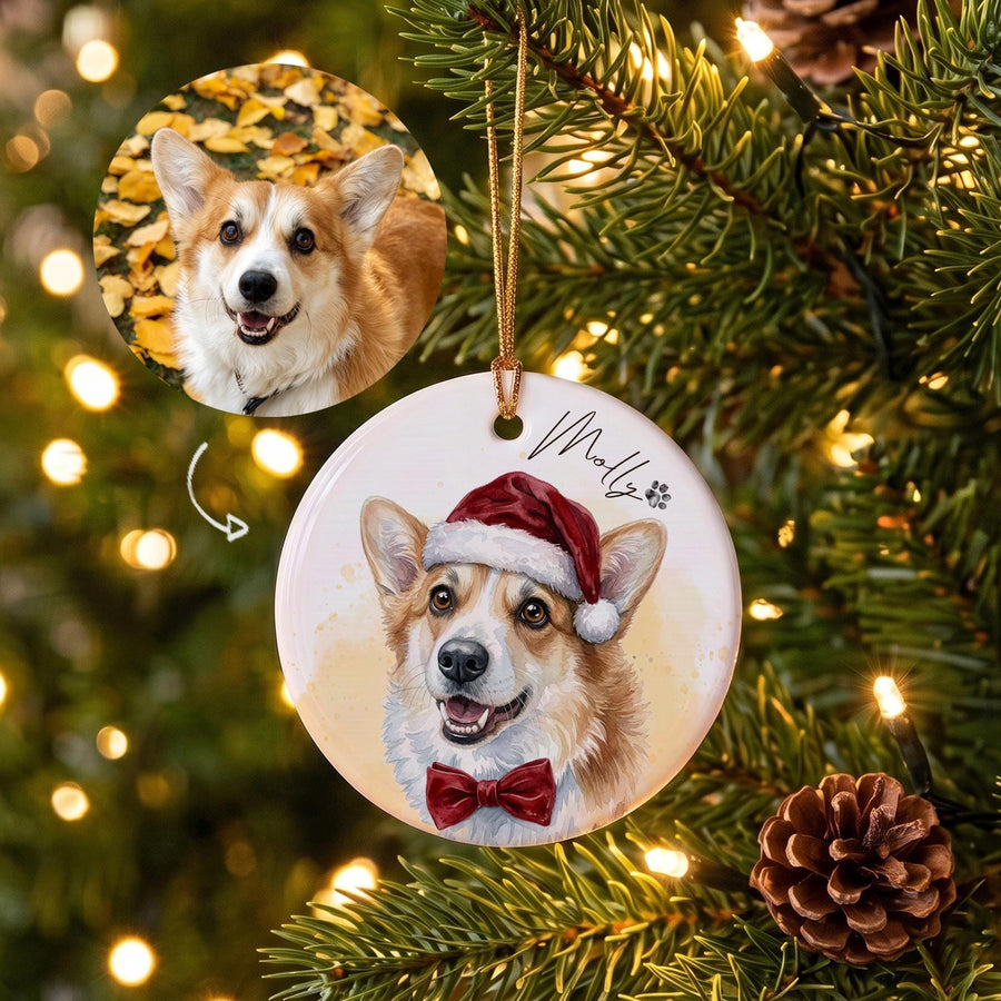 A round white ceramic Christmas ornament featuring a custom illustration of a Corgi dog wearing a red Santa hat and a red bow tie. The name Molly is printed in black script next to a small paw print. A gold string is attached for hanging.