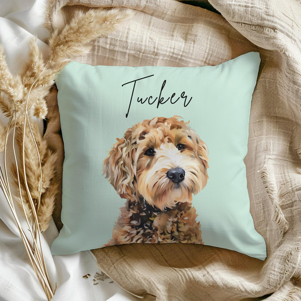 A light blue throw pillow with a brown and white dog illustration and the name "Tucker" written in black cursive.