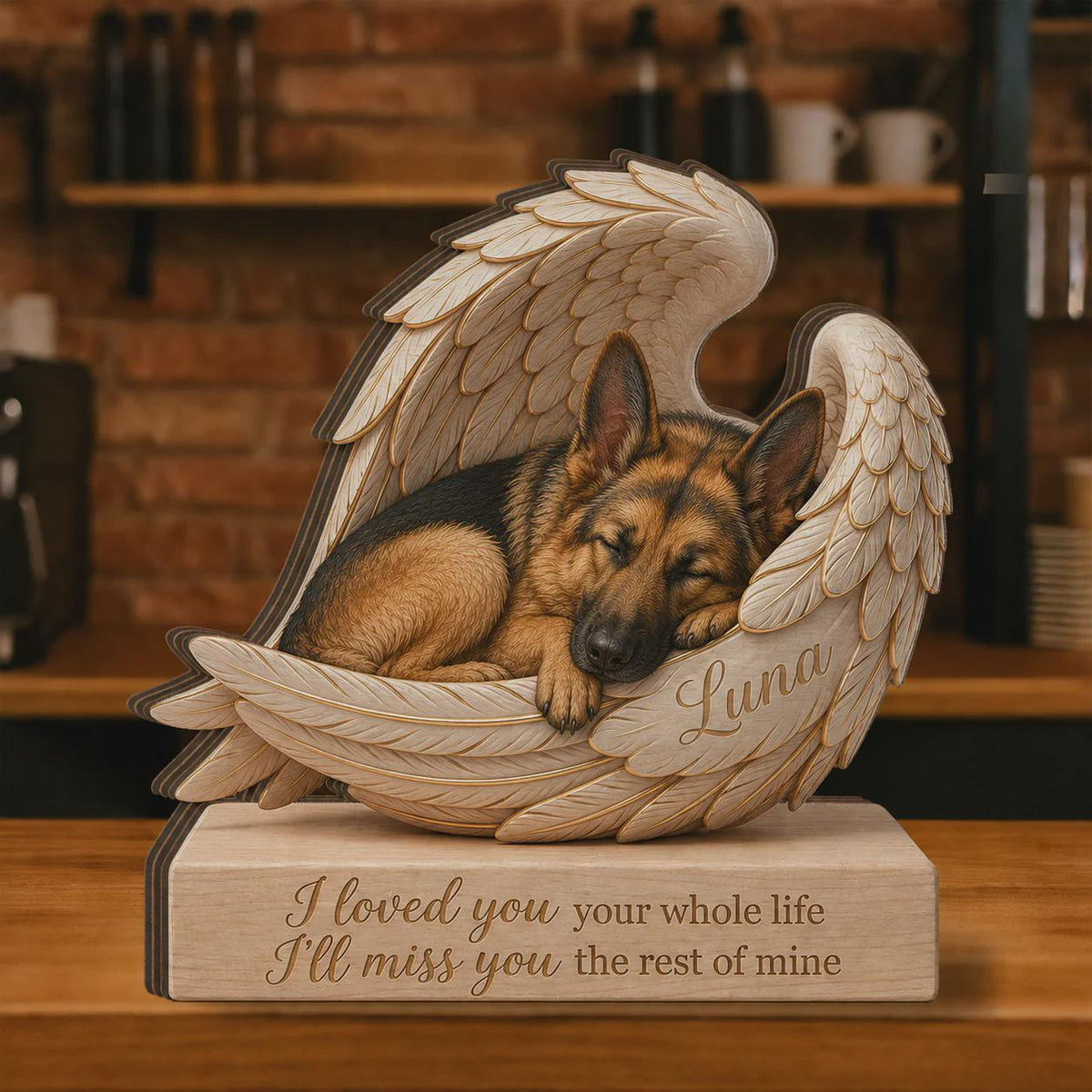 A wooden memorial sculpture featuring a sleeping German Shepherd dog nestled within large, carved angel wings. The name Luna is engraved on the wing, and the base displays the text: I loved you your whole life I'll miss you the rest of mine.